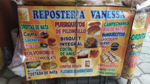 Letrero de la "Repostería Vanessa", con nombres de panes disponibles en el puesto.